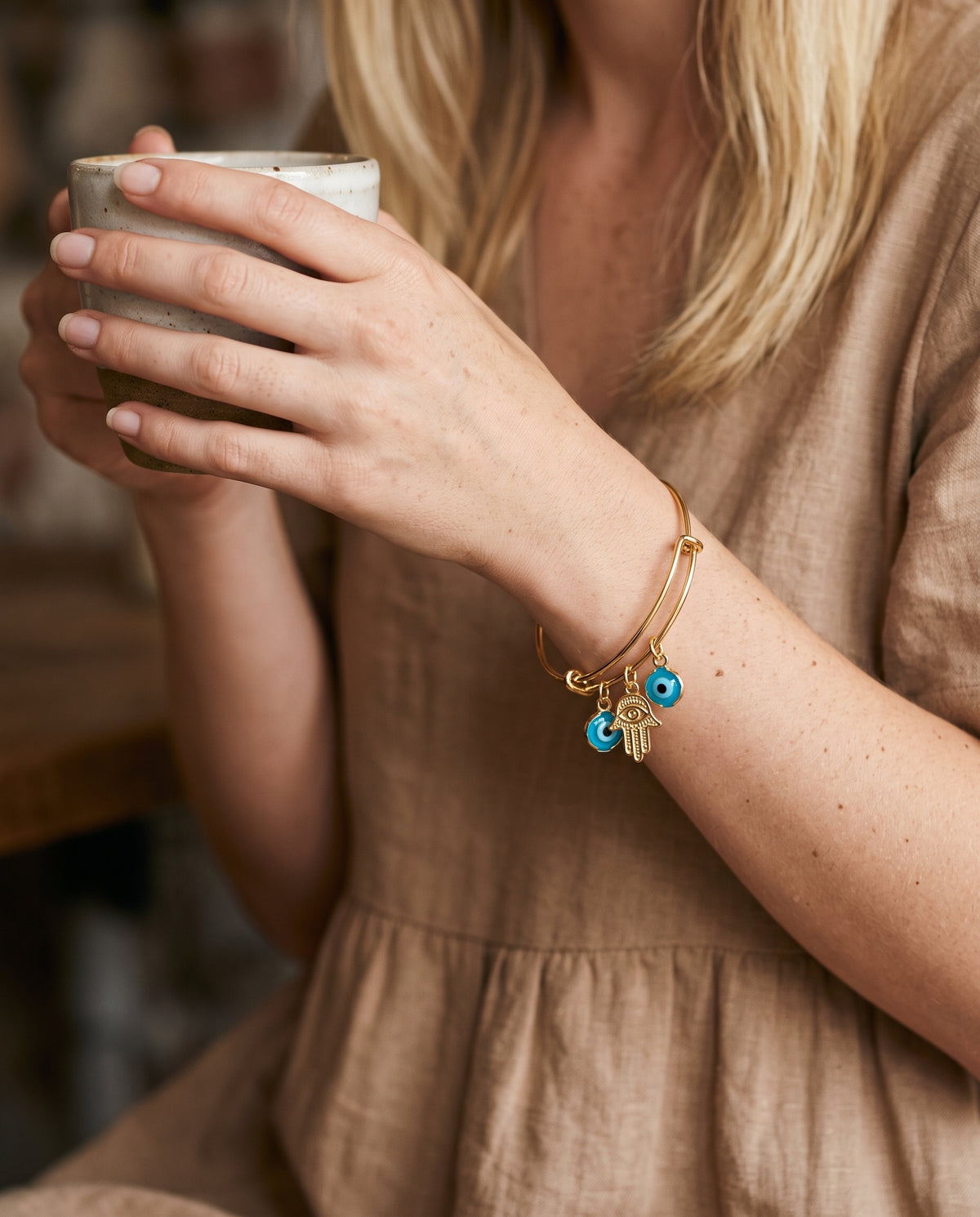 Gold Filled Dangling Evil Eye & Hamsa Bangle worn by a model